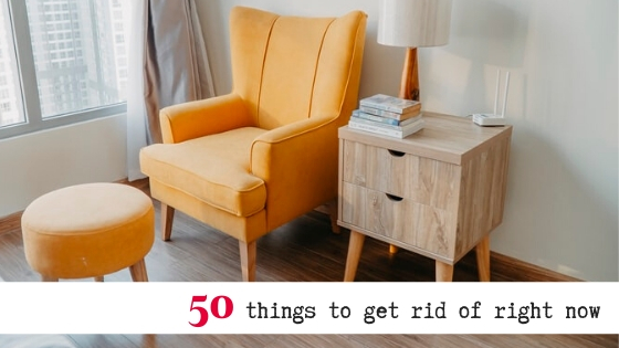 yellow armchair and matching footstool alongside bedside table and lamp in a room with text overlay that reads "50 things to get rid of right now"